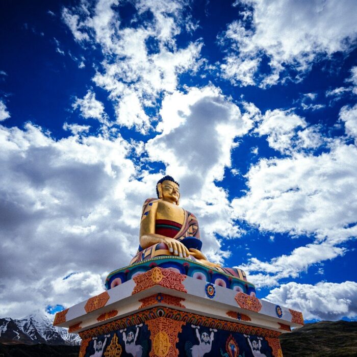 a golden buddha statue sitting on top of a hill