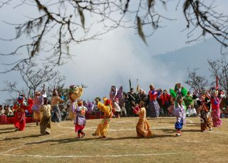people in brown and blue costume standing on brown field during daytime